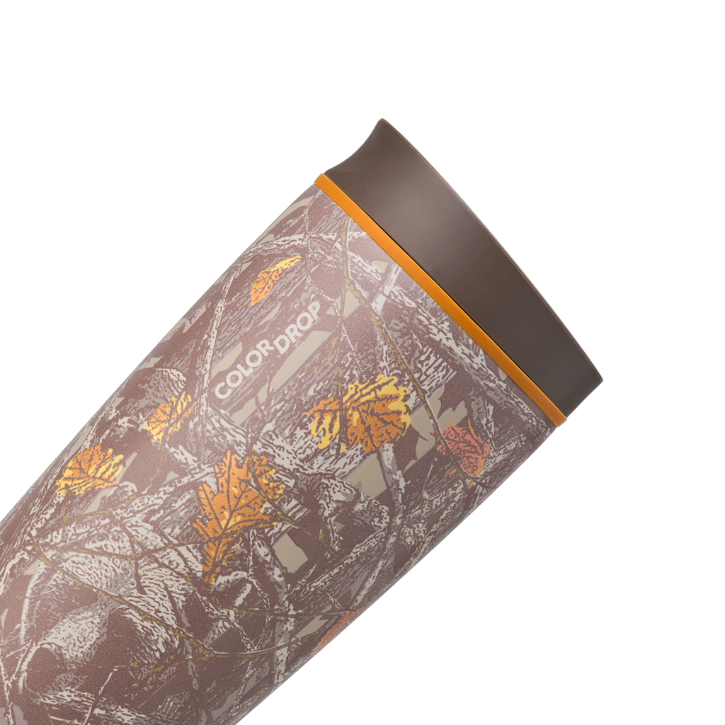 Owala SmoothSip Slider 20oz in Out of Sight, body close-up showing oak-leaf camouflage pattern with dark brown "COLOR DROP" print and orange accent ring at the lid base